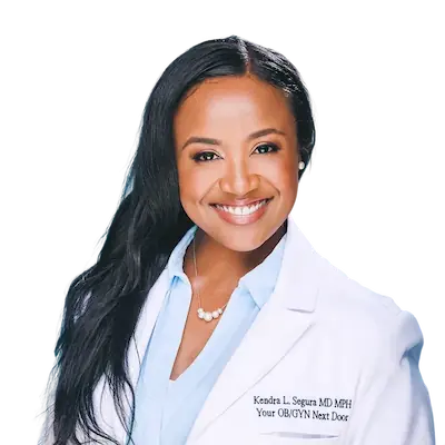 Headshot of Dr. Kendra L. Segura MD MPH, OB/GYN, Her Fantasy Box medical advisor smiling in white coat